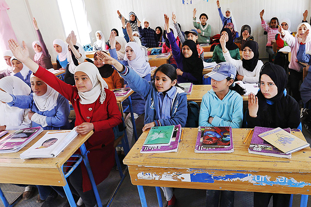 Syrian refugee students raise their hands as they attend class in a UNICEF school at the Al Zaatari refugee camp in the Jordanian city of Mafraq, near the border with Syria March 11, 2015. Nearly four million people have fled Syria since 2011, when anti-government protests turned into a violent civil war. Jordan says it is sheltering around 1.3 million refugees. REUTERS/Muhammad Hamed (JORDAN - Tags: CIVIL UNREST CONFLICT SOCIETY IMMIGRATION EDUCATION) ORG XMIT: AMM03