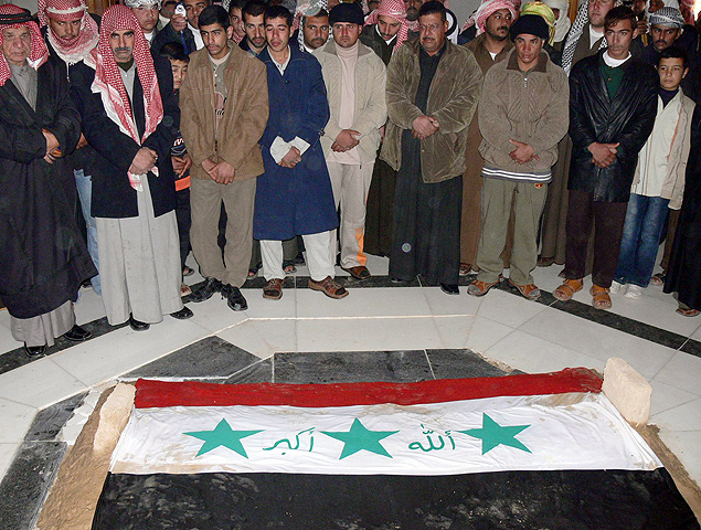Iraquianos sunitas lamentam a morte do ditador ao lado de seu tmulo, em dezembro de 2006