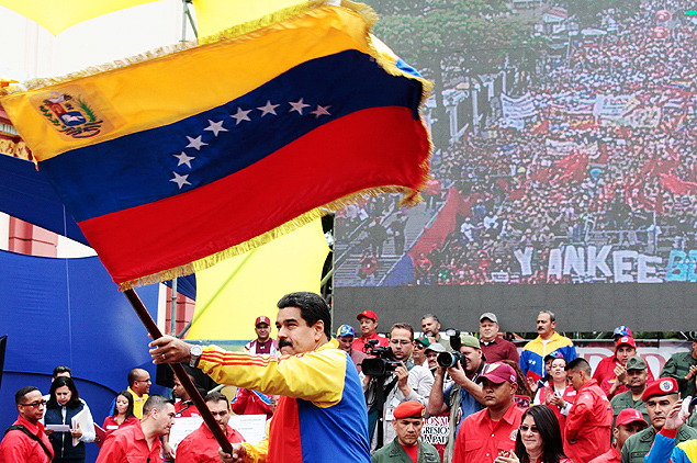 O presidente Nicols Maduro agita bandeira venezuelana em ato contra medidas dos EUA