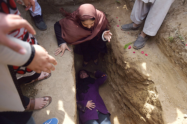 Ativista deita sobre a cova de Farkhunda, 27, que foi linchada aps falsa acusao de queimar o Alcoro