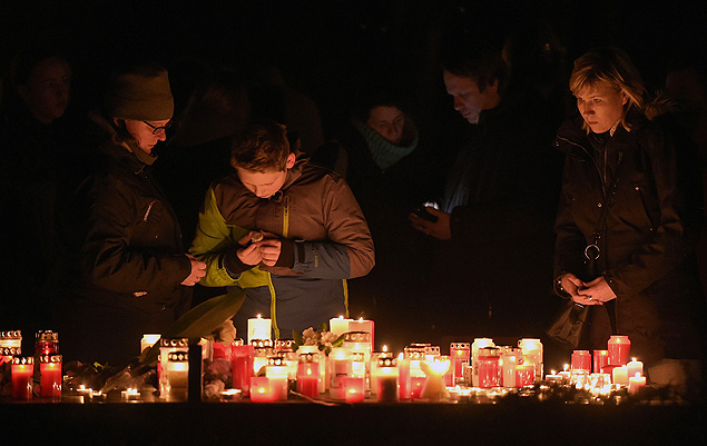 Pessoas acendem velas em frente da escola Josef-Knig-Gymnasium