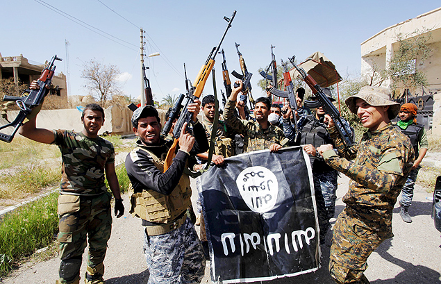 Soldados iraquianos celebram retomada do centro de Tikrit e exibem bandeira do EI capturada