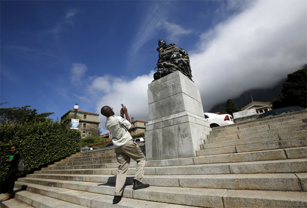 Homem fotografa esttua coberta do colonizador britnico Cecil John Rhodes, na Cidade do Cabo