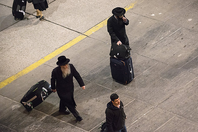 Judeus ultraortodoxos chegam ao aeroporto John F. Kennedy; homens no sentam ao lado de mulheres