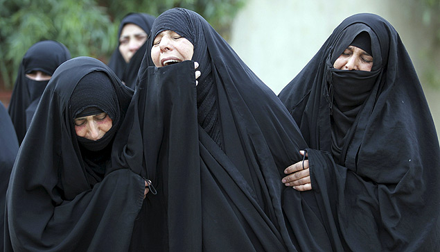 Mulheres choram em funeral de um agente de segurana morto neste sbado pelo Estado Islmico