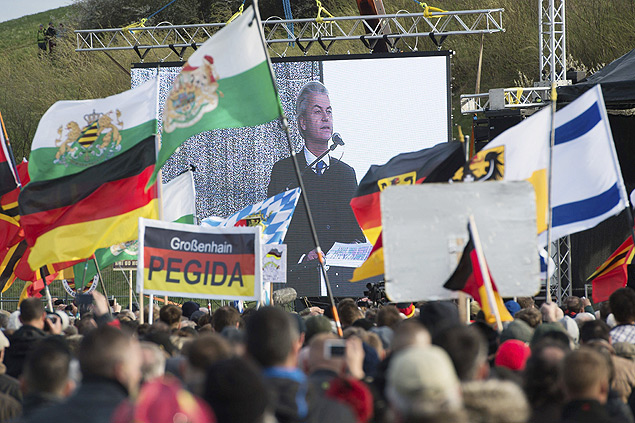 Manifestantes ligados ao Pegida assistem, no telo, ao discurso do poltico holands Geert Wilders durante evento em Dresden 