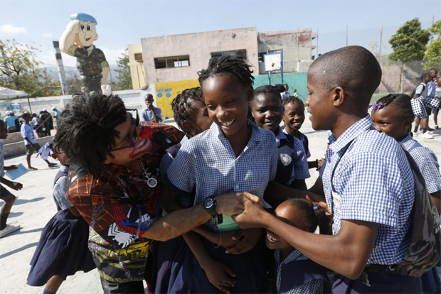 Sargento Ubirajara dos Santos, o palhao Tampico, brinca com jovens em uma escola na favela de Cit Soleil, na capital haitiana