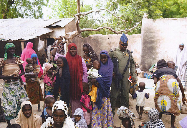 BEST QUALITY AVAILABLE This handout picture released by the Nigerian army on April 30, 2015 and taken this week in an undisclosed location in the Sambisa Forest, Borno state, purportedly shows a member of the Nigerian Army standing next to a group of women and children rescued in an operation against the Islamist group Boko Haram. Boko Haram hostages were held in atrocious conditions in the group's Sambisa Forest stronghold, Nigeria's military said on April 30 after nearly 500 women and girls were released this week. AFP PHOTO / NIGERIAN ARMY -- RESTRICTED TO EDITORIAL USE - MANDATORY CREDIT " AFP PHOTO / NIGERIAN ARMY " - NO MARKETING NO ADVERTISING CAMPAIGNS - DISTRIBUTED AS A SERVICE TO CLIENTS -- ORG XMIT: NIGERIA04 