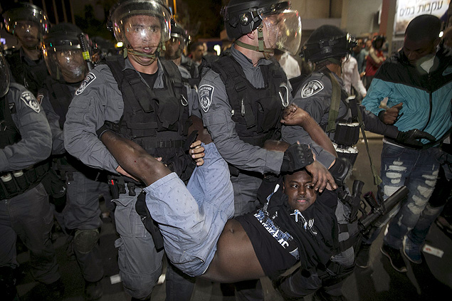 Manifestante judeu de origem etope  carregado por policiais durante protesto em Tel Aviv
