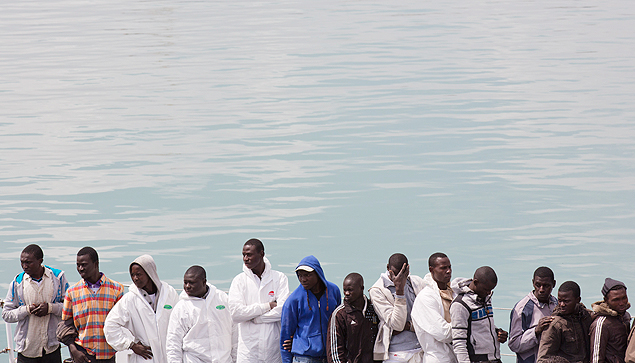 Imigrantes resgatados de naufrgio no Mediterrneo aguardam para desembarcar na Itlia