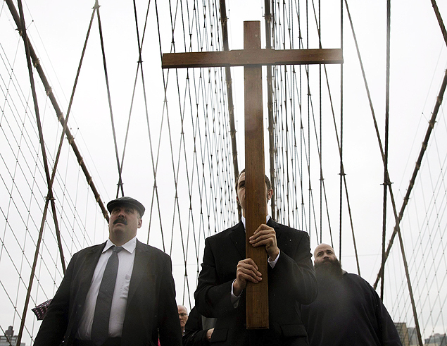 Cristos seguram cruz durante procisso na ponte do Brooklyn, em Nova York