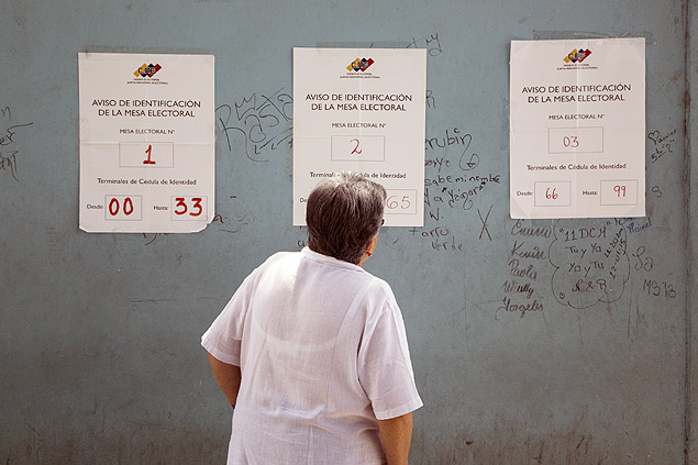 Mulher revisa listas em Caracas durante as primárias da oposição venezuelanas