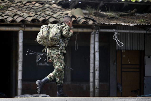 Soldado carrega seu equipamento por estrada no departamento de Cauca, onde ocorreu o ataque do governo na ltima semana