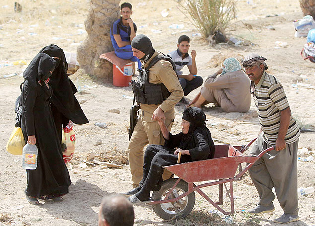 Idosa iraquiana que fugiu da cidade de Ramadi  carregada em carrinho de mo perto da ponte de Bzeibez, na fronteira com Bagd