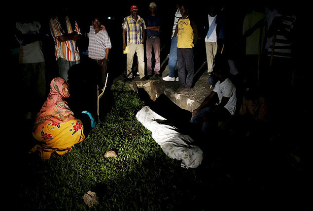 Corpo de Zedi Feruzi  cercado por parentes e amigos perto de sua casa na capital Bujumbura