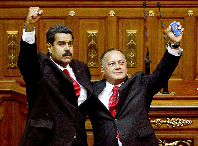 Presidente Nicols Maduro ( esq.) abraa Diosdado Cabello, que ergue Constituio venezuelana