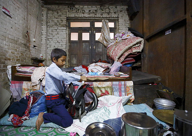 O nepals Niraj Ranjitkar, 10, arruma seu material para retornar  escola na cidade de Bhaktapur