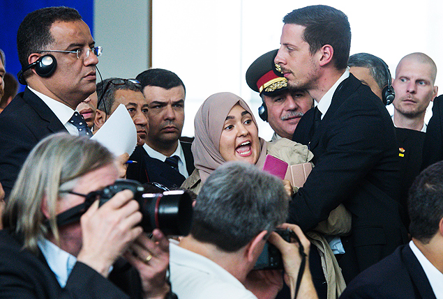 Uma mulher muulmana protesta durante a entrevista coletiva do presidente do Egito na Alemanha