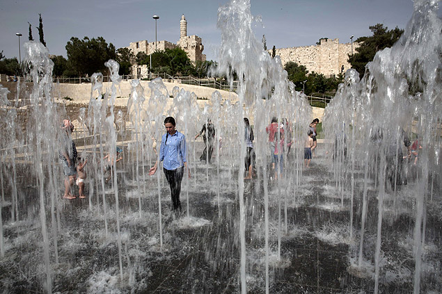 Pessoas se refrescam em fonte de Jerusalém durante onda de calor