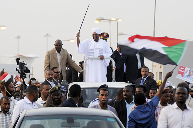 Ditador do Sudo, Omar al-Bashir, acena para partidrios aps desembarcar em Cartum