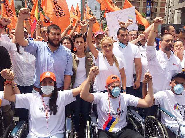 Lilian Tintori (ao centro, de cabelo loiro) e opositores do governo Maduro protestam em Caracas