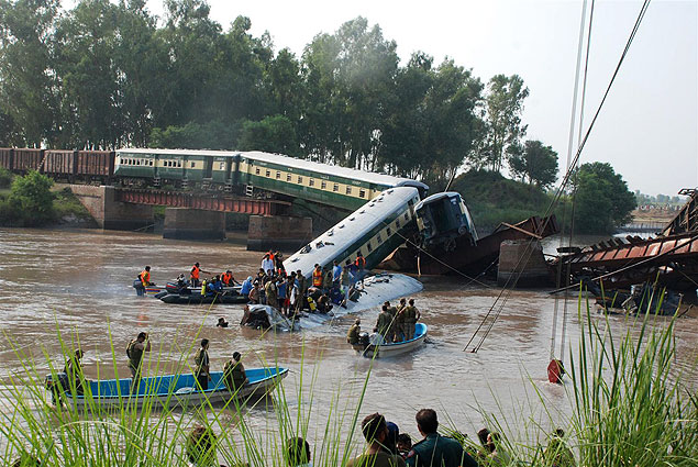 Moradores e equipes de resgate fazem buscas aps vages de trem despencarem em rio