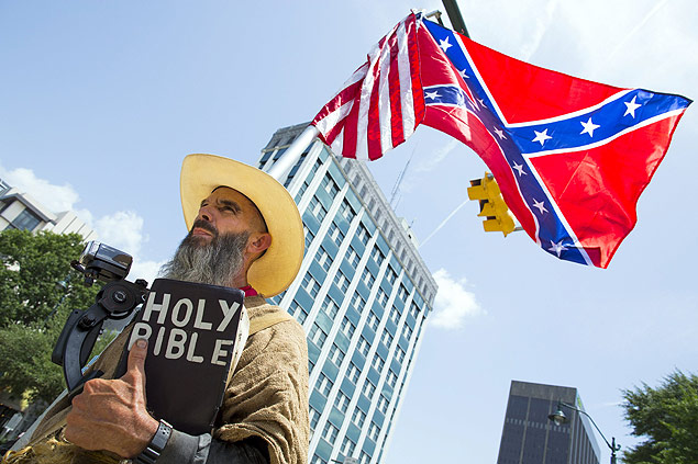 Alan Hoyle segura uma Bblia e uma bandeira confederada em protesto contra a retirada do smbolo 