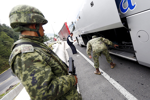 Soldados inspecionam um nibus em um posto de controle em um acesso a estrada da Cidade do Mxico, em busca de El Chapo