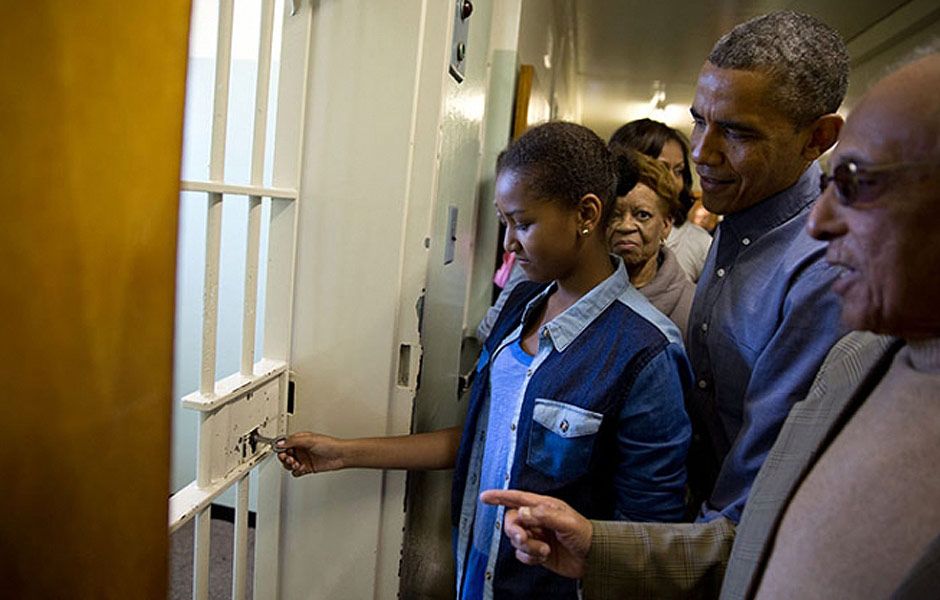 Barack Obama observa a filha Sasha abrindo cela em que Nelson Mandela ficou aprisionado durante visita a ilha Robben, na frica do Sul