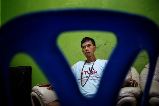 Lang Long, 30, assiste TV em abrigo, após ser resgatado de navio no mar do Sul da China