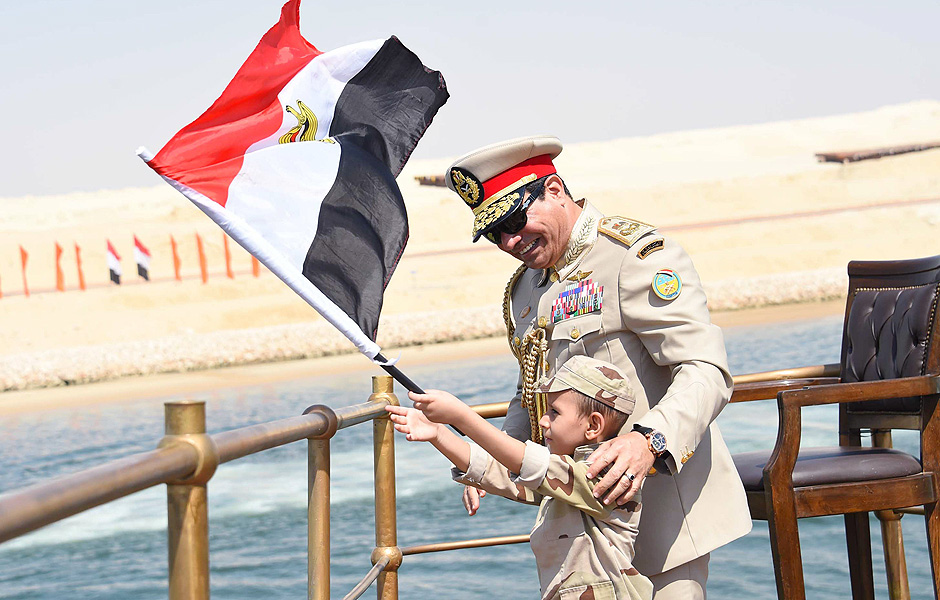 Menino segura bandeira do Egito ao lado do presidentee Sisi na inaugurao do novo canal de Suez