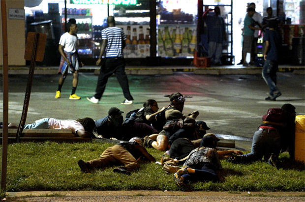 Manifestantes deitam no cho durante disparos em Ferguson, nos EUA