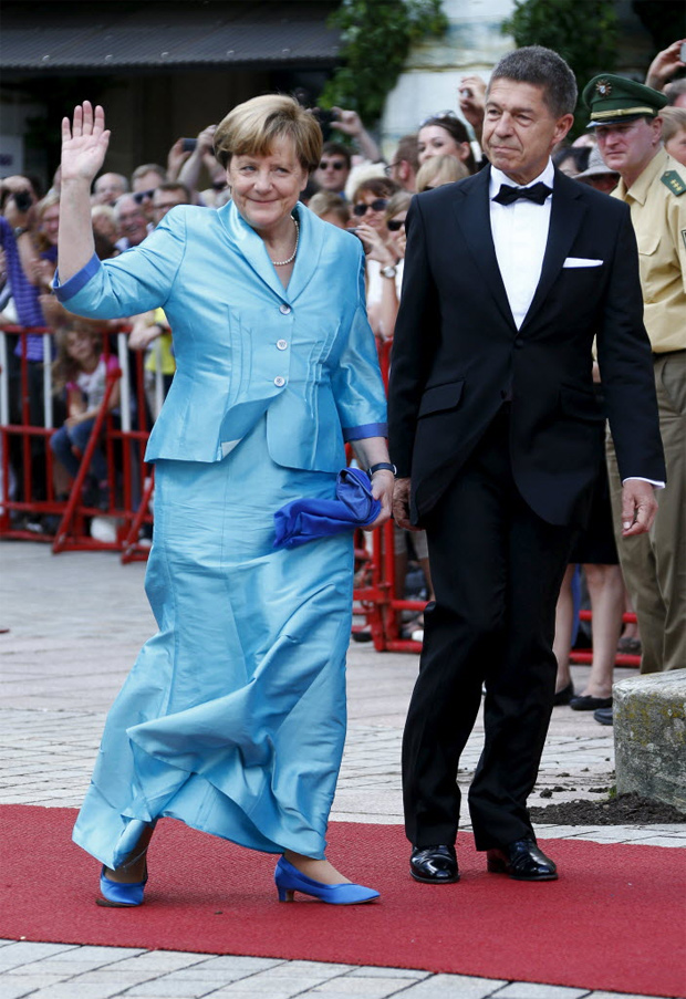 Ao lado do marido, Joachim Sauer, Merkel acena em um festival de pera na Alemanha