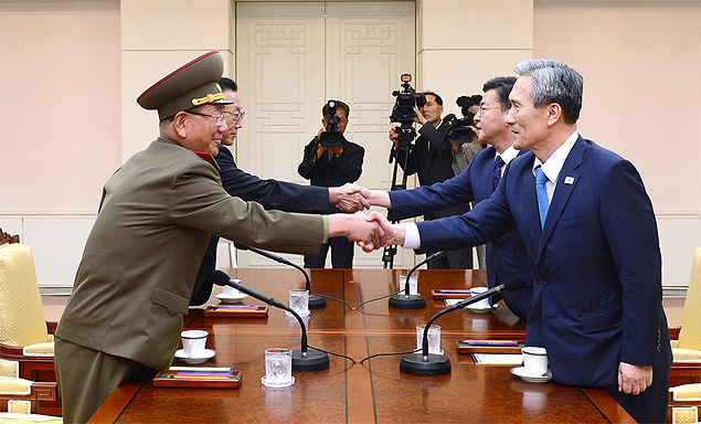 (150822) -- SEOUL, Aug. 22, 2015 (Xinhua) -- Hwang Pyong So (front, L), director of the General Political Bureau of the Korean People's Army of the Democratic People's Republic of Korea (DPRK), and Kim Kwan-jin (front R), chief of the National Security Office of South Korea, shake hands prior to their meeting in the truce village of Panmunjom, Aug. 22, 2015. The DPRK on Saturday held high-level urgent contact with South Korea in the truce village of Panmunjom to discuss the prevailing tense situation on the peninsula, the official KCNA news agency reported. (Xinhua) (djj)