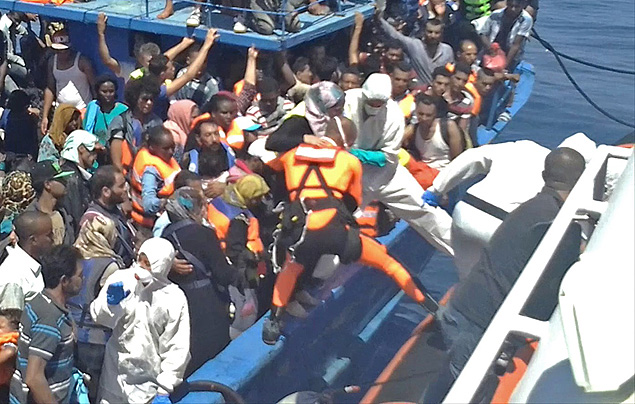 Imagem retirada de vdeo mostra Guarda Costeira italiana resgatando centenas de imigrantes em embarcao lotada na costa da Lbia 