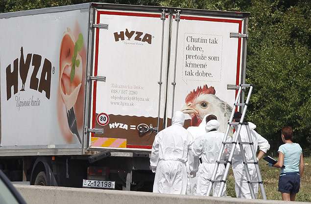 Forensic officers stand in front of a truck inside which where found a large number of dead migrants on a motorway near Neusiedl am See, Austria, on August 27, 2015. The vehicle, which contained between 20 and 50 bodies, was found on a parking strip off the highway in Burgenland state, police spokesman Hans Peter Doskozil said at a press conference with Interior Minister Johanna Mikl-Leitner. AFP PHOTO / DIETER NAGL ORG XMIT: agz1463