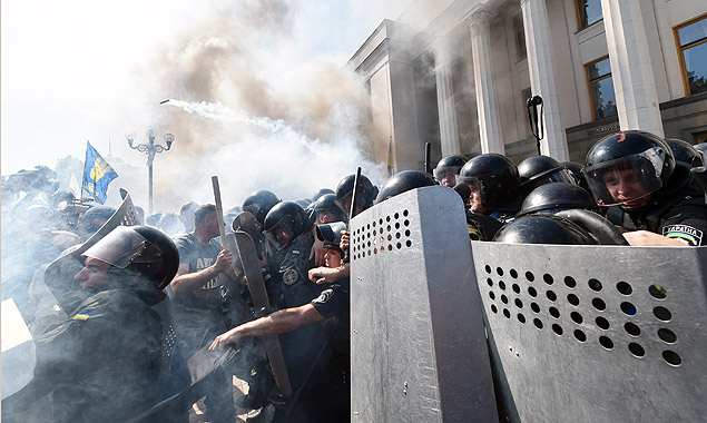 Smoke rises from the parliament building in Kiev as activists of radical Ukrainian parties, including the Ukrainian nationalist party Svoboda (Freedom), clash with police officers on August 31, 2015. At least 20 were wounded in clashes outside parliament in Kiev after lawmakers gave initial approval to constitutional changes granting more autonomy to pro-Russian separatists in eastern Ukraine. A loud blast was heard outside parliament shortly after the bill was passed, an AFP journalist said. Ukrainian interior ministry advisor and top lawmaker Anton Gerashchenko wrote on Facebook that attackers threw a hand grenade at National Guard troops guarding the building in what he called an "act of provocation." AFP PHOTO / SERGEI SUPINSKU ORG XMIT: SUP9483