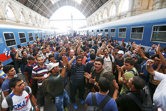 Migrants gesture as they stand in the main Eastern Railway station in Budapest, Hungary, September 1, 2015. Hungary closed Budapest's main Eastern Railway station on Tuesday morning with no trains departing or arriving until further notice, a spokesman for state railway company MAV said. There are hundreds of migrants waiting at the station. People have been told to leave the station and police have lined up at the main entrance, national news agency MTI reported. REUTERS/Laszlo Balogh ORG XMIT: CVI1996