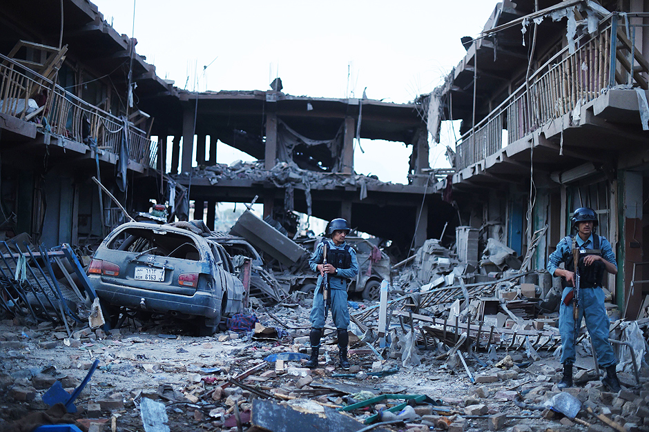 Policiais afegãos vigiam mercado onde atentado a bomba com caminhão deixou sete mortos e mais de cem feridos