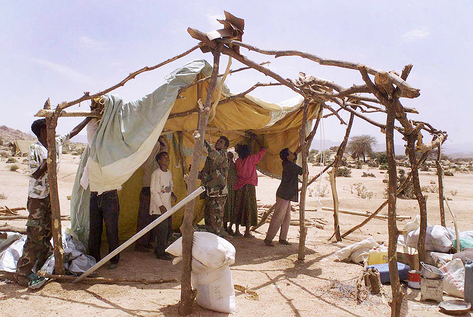 Soldados da Eritreia ajudam família a erguer tenda em campo de refugiados em Afabet, devido a ofensiva da Etiópia