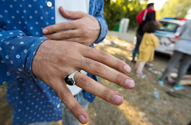 In this photo taken Sunday, Aug. 30, 2015, Mohammad Zamani, 26, a high school maths teacher from Shiraz, Iran, shows his ring after crossing from Serbia to Asotthalom, Hungary. Zamani had a bag full of belongings when he left his home nearly a month ago, but the bag is gone now. Fortunately for Zamani, he didn't lose his most prized possession with his bag: a ring of silver and black stone that his older brother gave to him as a 25th birthday present. (AP Photo/Darko Bandic) ORG XMIT: XDB509