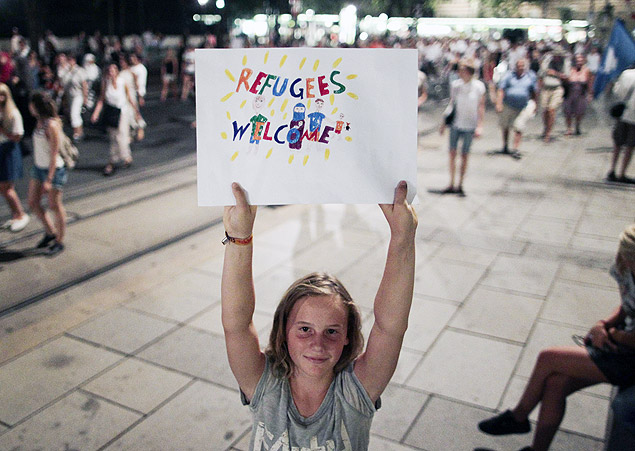 A protester holds a banner during a rally against ill-treatment of migrants after the bodies of 71 refugees were found in an abandoned truck last week in Vienna on August 31, 2015. Around 20,000 people demonstrated police said. The banner reads 'Muslims and refugees welcome'. AFP PHOTO / PATRICK DOMINGO ORG XMIT: 9239