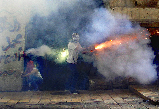 (150915) -- JERUSALEM, Sept. 15, 2015 (Xinhua) -- Palestinians confront with Israeli police officers at a gate of al-Aqsa Mosque in the Old City of Jerusalem, on Sept. 15, 2015. Clashes between Israeli police and Palestinian protesters continued on Tuesday at East Jerusalem's flashpoint al-Aqsa compound for the third consecutive day of violence at the holy site. Police spokeswoman said that Israeli forces raided the compound to disperse a group of protesters who barricaded themselves inside the mosque overnight. (Xinhua/Muammar Awad)