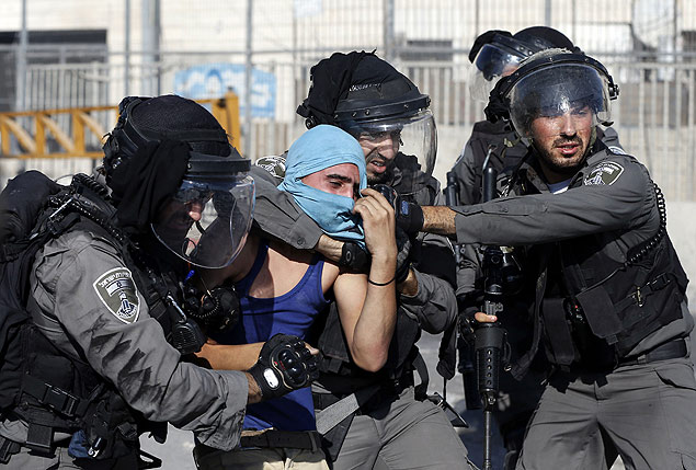 Soldados israelenses prendem jovem palestino durante protesto em Shuafat, no leste de Jerusalm
