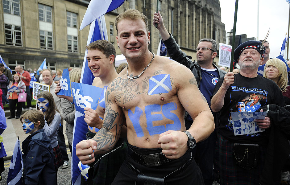 A pro-independence supporter with a Saltire flag and a "Yes" written on his body joins a march and rally in Edinburgh on September 21, 2013 in support of a yes vote in the Scottish Referendum to be held in September 2014. Voting for Scottish independence is "common sense", First Minister Alex Salmond, the leader of the movement to break away from the United Kingdom insisted on September 18 a year to the day before Scotland votes in a referendum. AFP PHOTO / ANDY BUCHANAN ORG XMIT: DAN221