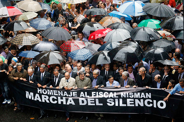 Manifestantes seu renem, em ato protesto para exigir respostas do governo na misteriosa morte do promotor Alberto Nisman, no icnico Plaza de Mayo, em Buenos Aires (Argentina). *** Protesters hold a banner during a silent march to honor late state investigator Alberto Nisman in Buenos Aires February 18, 2015. Tens of thousands of Argentines are expected to march in silence through Argentina's capital, Buenos Aires, on Wednesday evening to honor Nisman, a state investigator who was poised to detail evidence behind his accusations that Argentine President Cristina Fernandez plotted to cover up his investigation into a 1994 bombing. Nisman was found dead with a single bullet to the head on January 18. The banner reads, "Homage to investigator Nisman. March of Silence." REUTERS/Enrique Marcarian (ARGENTINA - Tags: POLITICS CIVIL UNREST CRIME LAW) ORG XMIT: TBR01