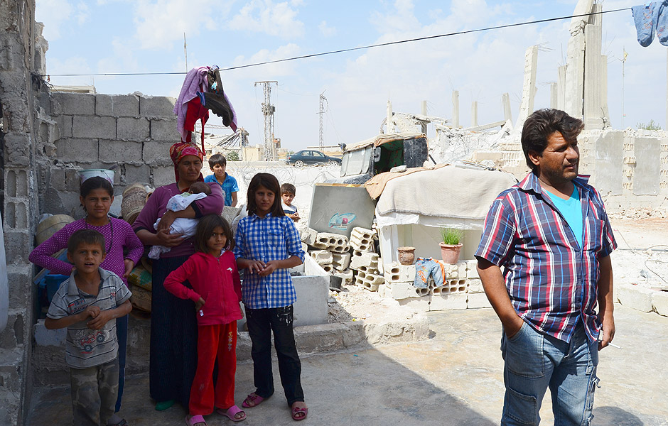 Famlia que teve a casa destruda na cidade de Kobani (norte da Siria, na fronteira com a Turquia) hoje mora em runas