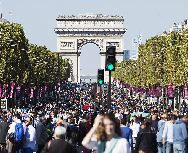 Pedestres e ciclistas passeiam pela avenida Champs-Elyses neste domingo