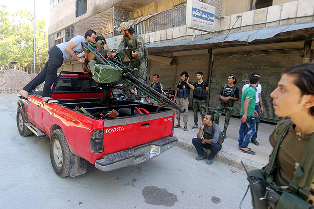 Integrantes do Exrcito Livre da Sria inspecionam arma antes de combater militantes do EI em Aleppo 