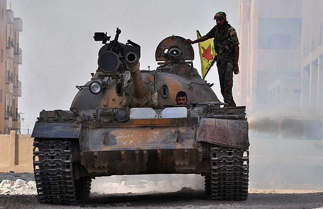 Combatentes curdos se deslocam em tanque durante batalha na cidade de Hasakah, na Sria, em agosto